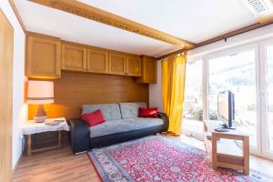 ein Wohnzimmer mit einem Sofa und einem TV in der Unterkunft Chalet Drei Brüder in Bruck an der Großglocknerstraße