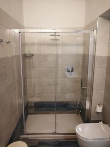 bagno con doccia in vetro e servizi igienici di Appartamenti Acquazzurra a Portoferraio