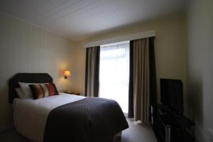 a hotel room with a bed and a television at Gipsy Hill Hotel in Exeter