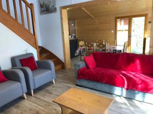 a living room with a red couch and two chairs at Chalet O FIL DE L EAU , jusque 6 pers , à XONRUPT LONGEMER in Xonrupt-Longemer