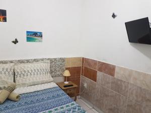 a bedroom with a bed and a tv on the wall at Sobrado Botafogo Guesthouse in Rio de Janeiro