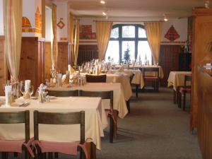 ein Esszimmer mit Tischen und weißen Tischdecken in der Unterkunft Hotel Danis in Lenzerheide