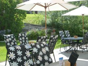 a group of chairs with an umbrella and a table at Hotel Danis in Lenzerheide