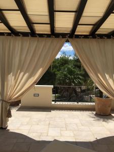 a large room with curtains and a patio at Serra Peccatori in Specchia