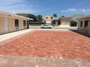 a car parked in a parking lot with a brick driveway at A1A Travel Inn in Ormond Beach