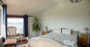 een slaapkamer met een bed, een stoel en een raam bij Хотел "Лодката" in Tutrakan