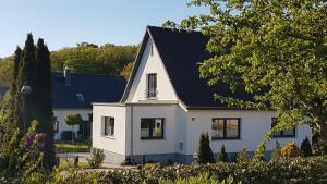 una casa blanca con techo negro en Ferienhaus Meeresrauschen en Binz