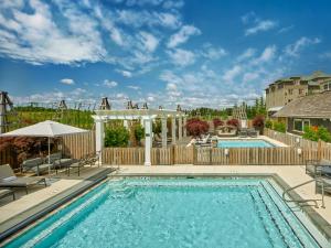 uma piscina com uma cerca de madeira e uma piscina de natação em The Inn at Chesapeake Bay Beach Club em Stevensville