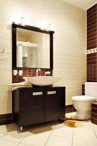 y baño con lavabo, aseo y espejo. en Raina Lux Apartment, en Riga