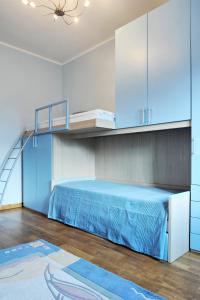 1 dormitorio con 1 cama con sábanas y armarios azules en Raina Lux Apartment, en Riga