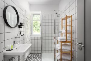 a white bathroom with a sink and a mirror at Hotel Orlík in Teplice nad Metují