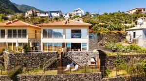 ein Haus auf einem Hügel mit einer Steinmauer in der Unterkunft Madeira Offline - Ponta Delgada in Ponta Delgada