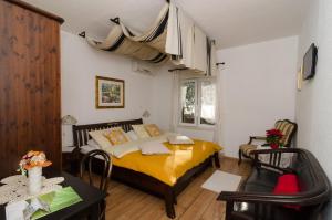 1 dormitorio con cama amarilla, mesa y sillas en B&B Villa Dubrovnik Garden, en Dubrovnik