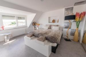 a white bedroom with a large bed and a window at The Waterside Designer Waterfront Oasis Spa & Sauna Terrace in Zwanenburg