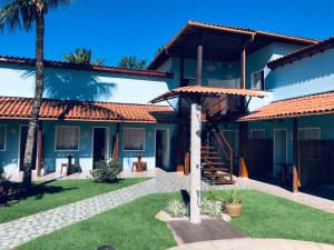 a house with a courtyard with palm trees at Pousada Universo in Arraial d'Ajuda