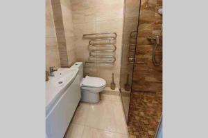 a bathroom with a toilet and a tub and a shower at Home sweet home in Radviliškis