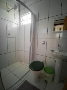 a bathroom with a shower and a toilet and a sink at Casa do Juá in Lavras