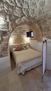 ein Schlafzimmer mit einem Bett in einer Steinmauer in der Unterkunft I Trulli Di Spinaruta in Grottaglie