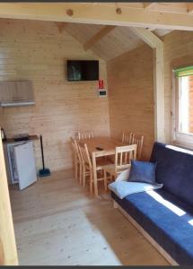 una habitación con una mesa y un sofá en una cabaña en Domki w sadzie Stegna en Stegna