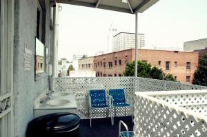 a balcony with a sink and two blue chairs at Little Tokyo Hotel in Los Angeles
