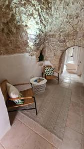 sala de estar con muebles y pared de piedra. en I Trulli Di Spinaruta en Grottaglie