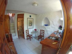 een keuken met een wastafel en een tafel en stoelen bij Casa Condesa - El Guro - Valle Gran Rey - La Gomera in Calera