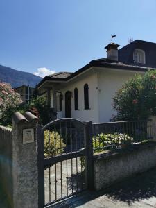 una recinzione nera di fronte a una casa bianca di Casa Vacanze - Residenza Elvezia a Tirano