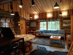 a living room with a couch and a table at Logwood Villa Restamaja in Luosto