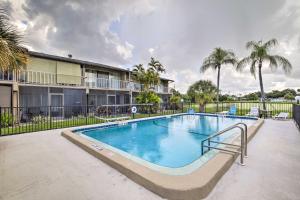 萨拉索塔Condo with Pool Access Less Than 4 Miles to Siesta Key Beach的棕榈树环绕的建筑物前的游泳池