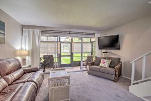 a living room with a couch and a tv at Condo with Pool Access Less Than 4 Miles to Siesta Key Beach in Sarasota