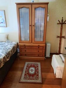 - une chambre avec un lit et une commode avec une croix dans l'établissement Charmoso Apartamento em Gramado, à Gramado
