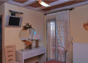a room with a mirror and a table and a television at Hani Mpagasaki in Koryshades