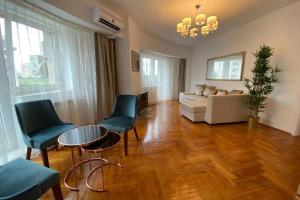 Una sala de estar con un sofá, una mesa y sillas. en New Luxury Flat in front of the Parliament at Unirii, en Bucarest