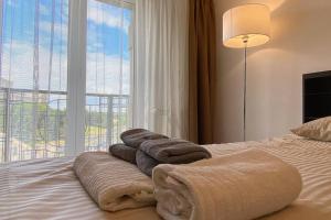 una pila de toallas en una cama con ventana en New Luxury Flat in front of the Parliament at Unirii, en Bucarest