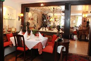 a dining room with a table with red chairs at Hotel Restaurant Da Franco in Rastatt