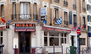 a building with signs on the side of a street at Hotel Victor Hugo in Clamart