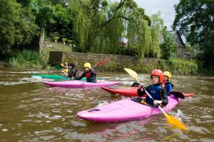a group of people kayaking down a river at Rives Nature in La Gacilly