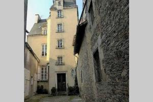 un antiguo edificio con una torre encima en Charmant Duplex Centre Historique Vitré, en Vitré