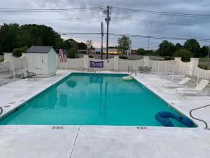 una piscina con agua azul y sillas en Stay Express Inn & Suites Demopolis, en Demopolis
