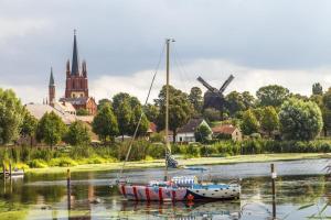 een paar boten in het water met een windmolen bij Ferienwohnung 2 in Glindow