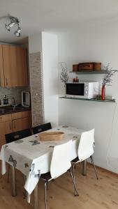 cocina con mesa con sillas y microondas en Wohnung im Grünen, en Fürth