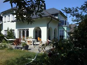 ein weißes Haus mit einem Tisch und Stühlen im Hof in der Unterkunft Ferienwohnung Moosdorf in Stützengrün