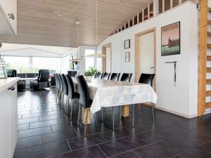 a dining room with a table and black chairs at 14 person holiday home in V ggerl se in Marielyst