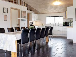 14 person holiday home in V ggerl se في Bøtø By: مطبخ مع طاولة وكراسي سوداء