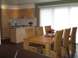 a kitchen with a wooden dining room table and chairs at De Jölenberg in Heers