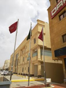 un edificio con banderas delante en شقق درر رامه للشقق المخدومة 6, en Riad