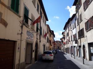 biały samochód zaparkowany na ulicy obok budynków w obiekcie CASA FEDORA -Appartamento uso turistico centro storico di Arezzo w Arezzo
