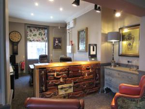 una sala d'attesa con scrivania e orologio di The Rutland Arms Hotel, Bakewell, Derbyshire a Bakewell