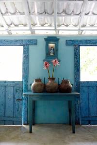 a table with three vases and flowers on it at UXUA Casa Hotel & Spa in Trancoso