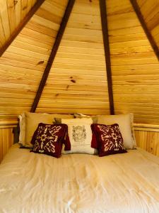 Cama en habitación de madera con almohadas en The Victorian on Main en Fairfield